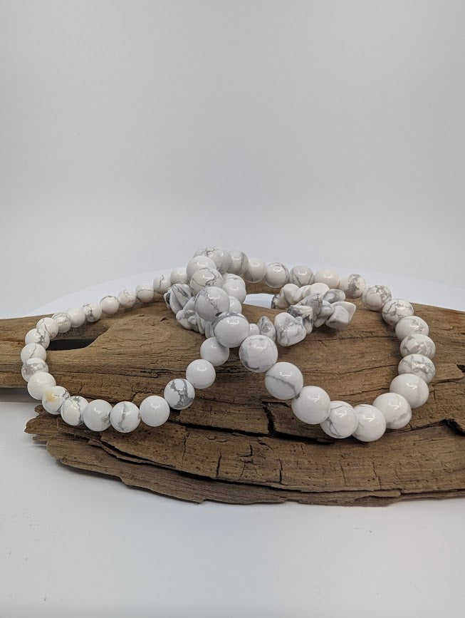 Howlite bracelets — chip, 6mm and 8mm — displayed on driftwood with soft grey veining