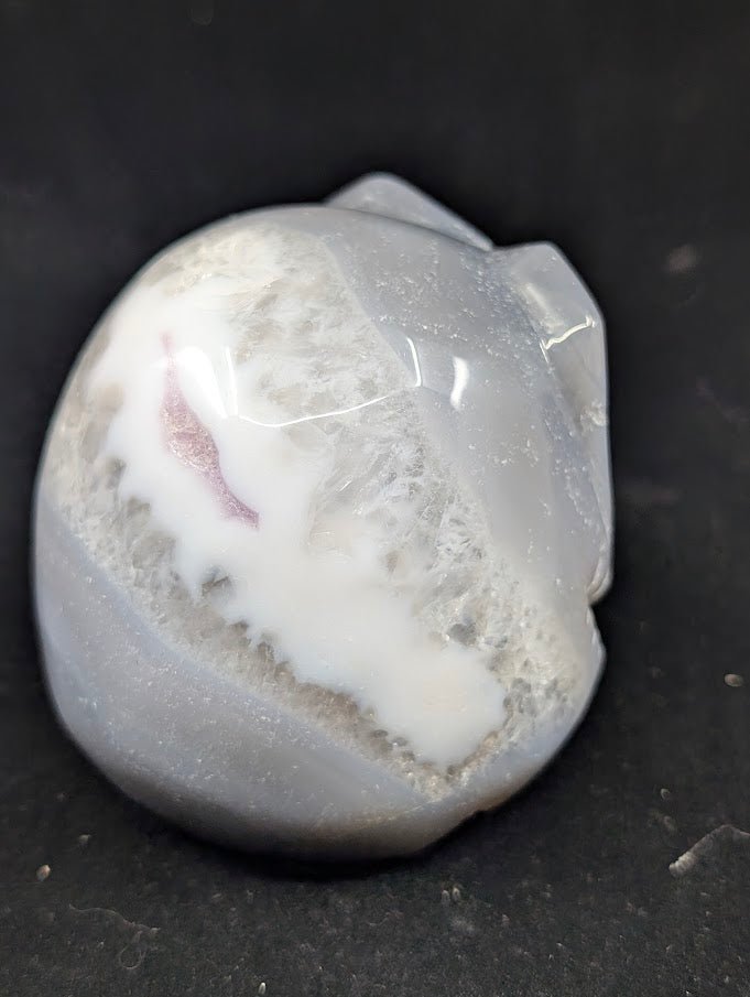 Detail of Ocean Agate Jack Skellington carving showing soft grey banding and glossy polish back side view
