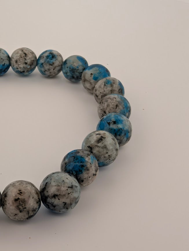Angled close-up of K2 beads with graphic grey matrix and blue inclusions