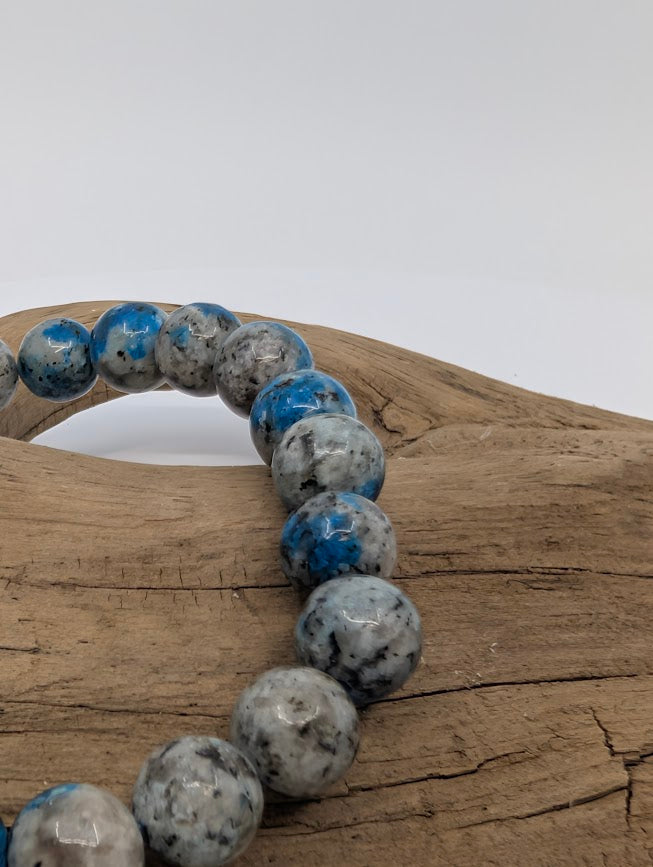 Macro of K2 beads highlighting vivid cobalt azurite spots in pale granite