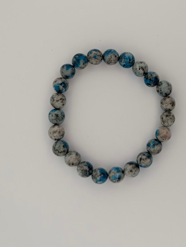 Overhead view of K2 8mm bracelet on light background