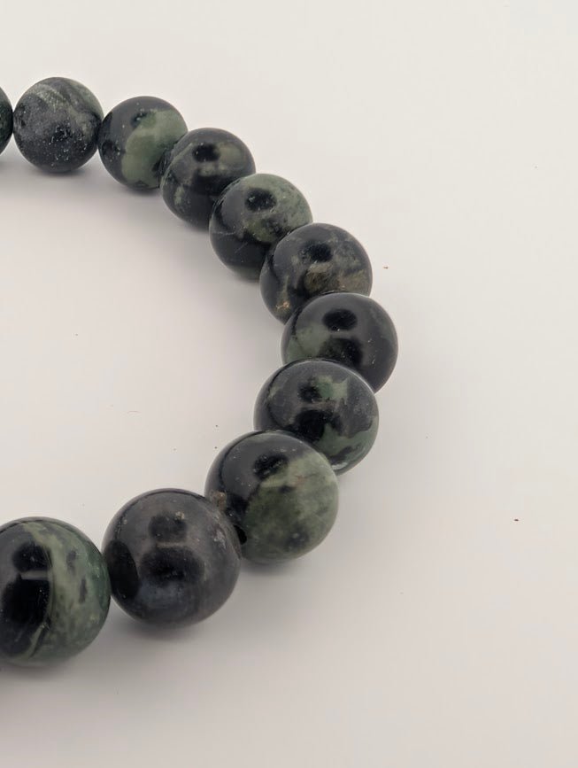 Angled macro of Kambaba Jasper bracelet with forest-green tones and natural patterning