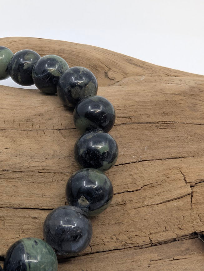 Close-up of Kambaba Jasper beads highlighting glossy polish and swirling orbs