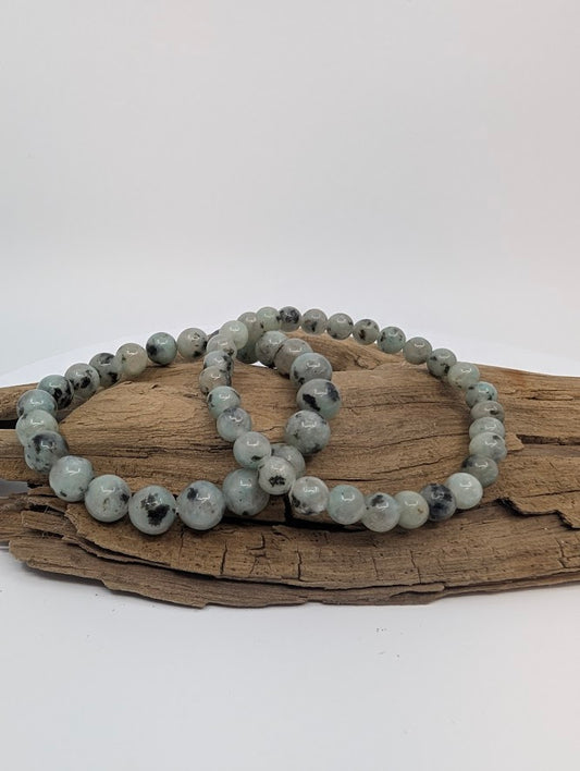 Kiwi Jasper gemstone bracelets in 6mm and 8mm round beads on driftwood.