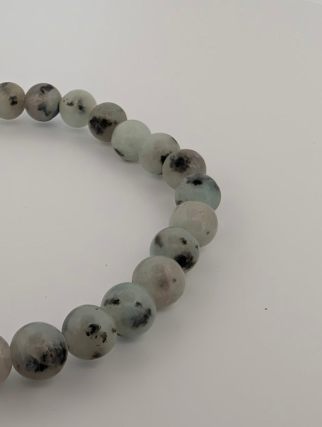 Angled macro of Kiwi Jasper bracelet with sea-foam green tones and charcoal inclusions