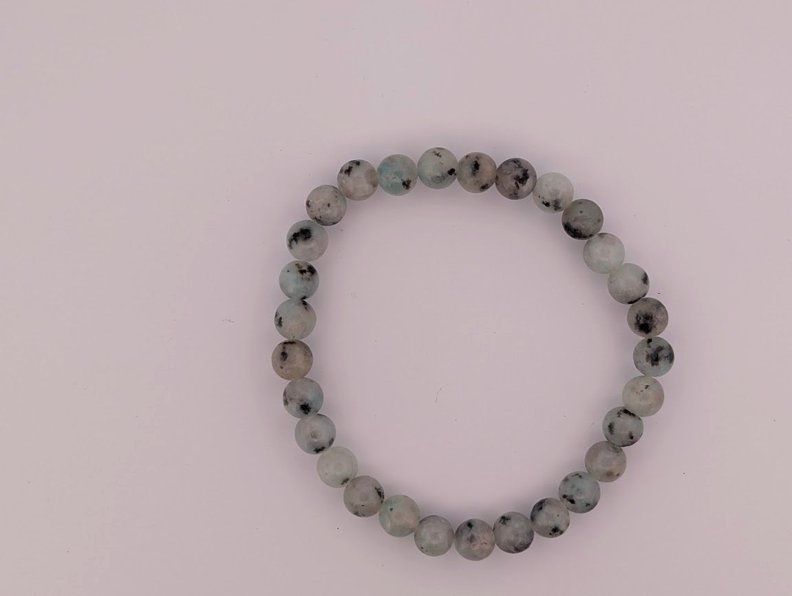 Overhead view of Kiwi Jasper 8mm bracelet on light background