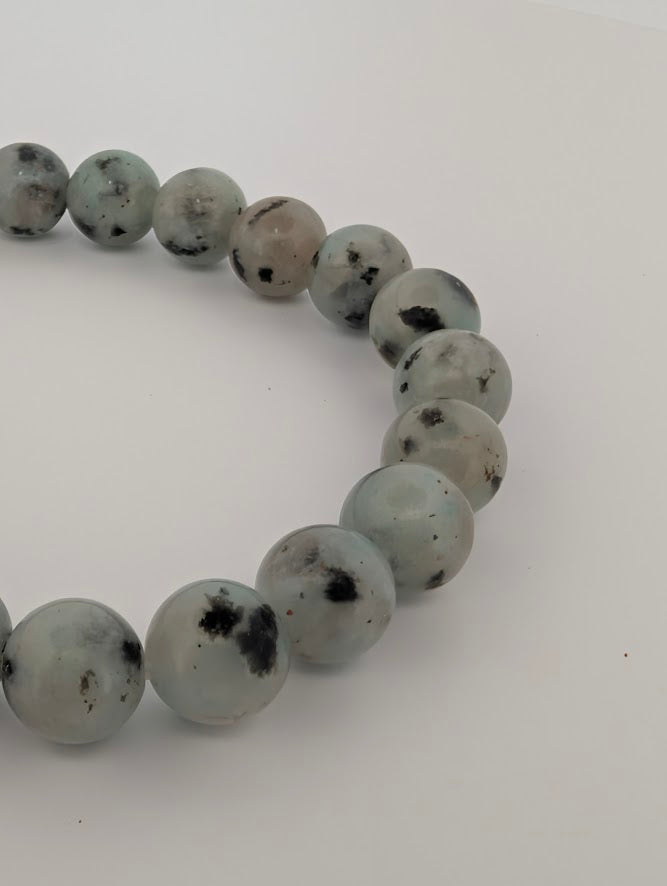Close-up of 8mm Kiwi Jasper bracelet highlighting glossy polish and spots.
