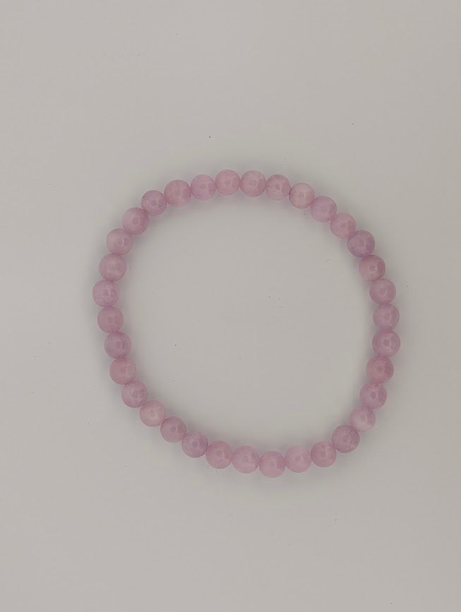 Overhead view of 6mm Kunzite bracelet on light background