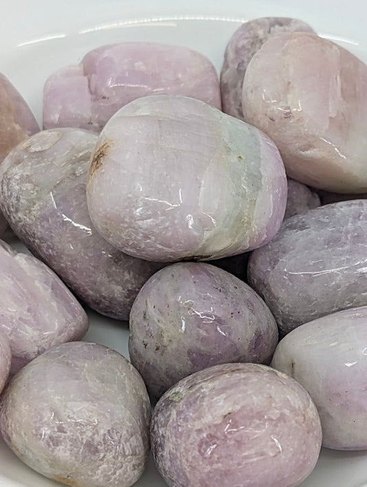 Close-up of Kunzite tumbled stones showing lilac and pink zoning
