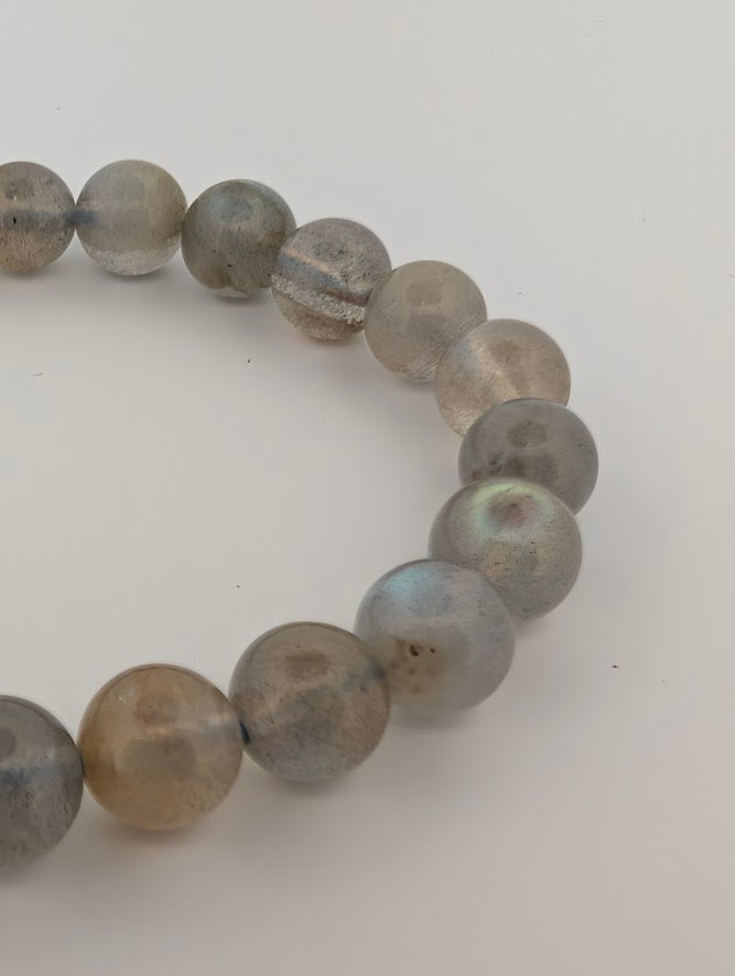Close-up of 8mm labradorite round bead bracelet showing blue-green iridescent flash.