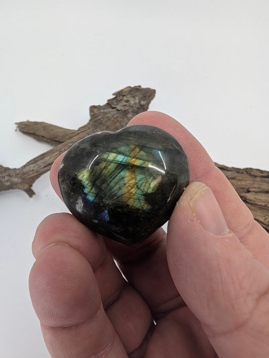 Hand holding a 25g Labradorite heart showing blue labradorescence.