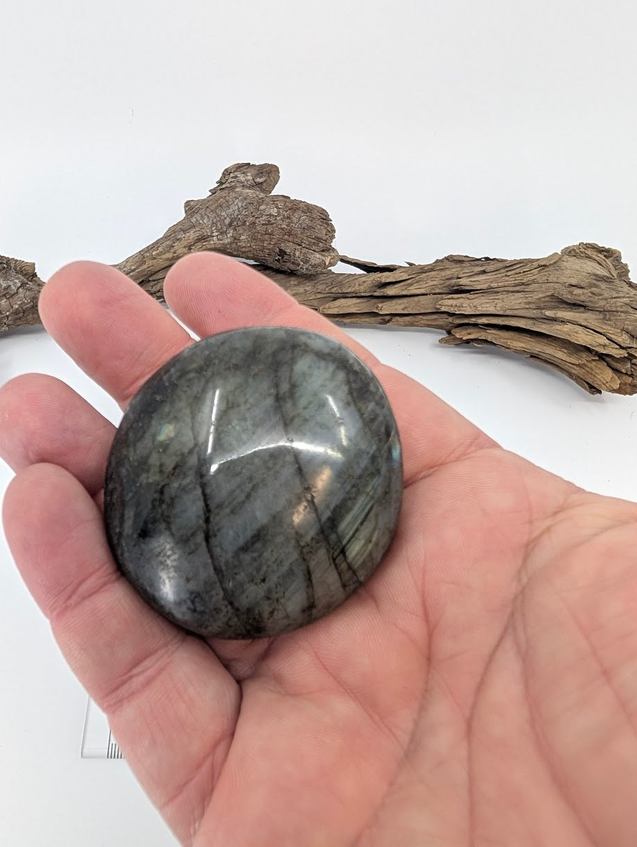Labradorite palm stone shown in hand for scale and polish