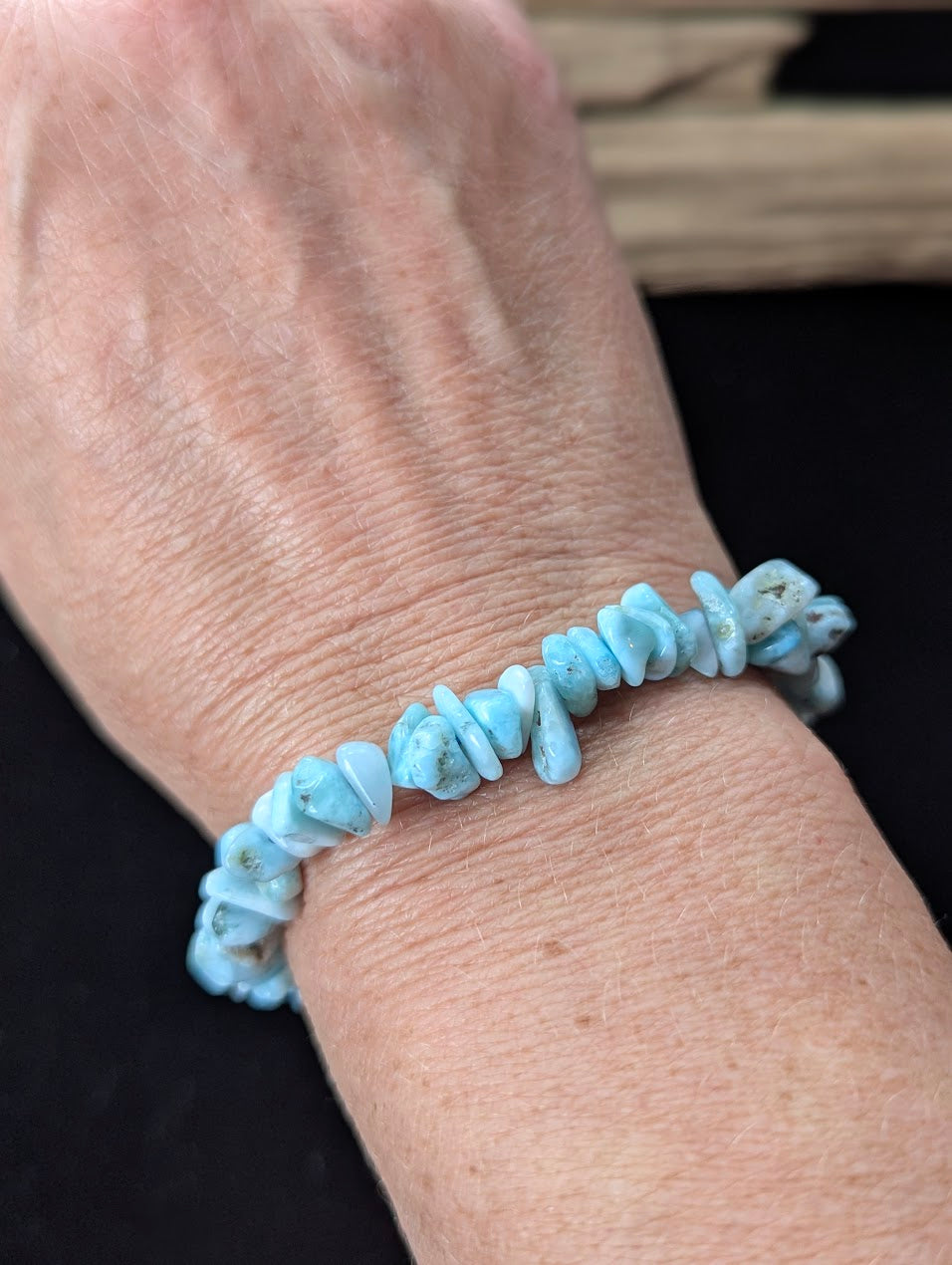 Larimar freeform chip bracelet worn on a wrist, demonstrating the organic texture and beautiful tropical water aesthetic.