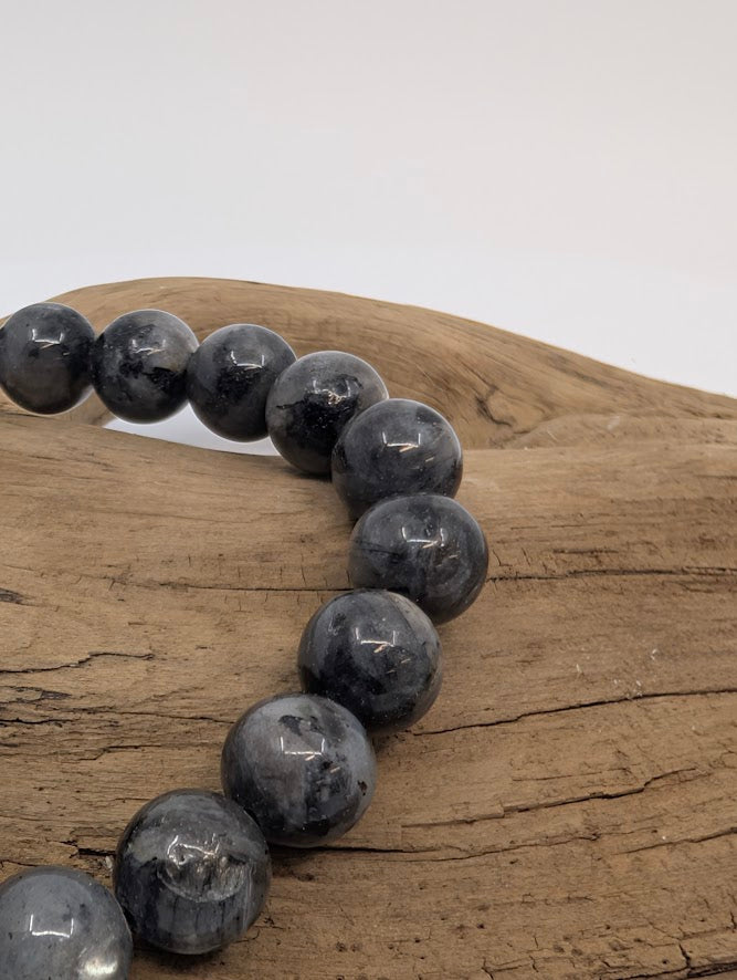 Close-up of Larvikite beads showing silver-blue flash and polished finish