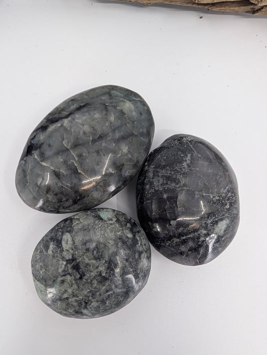 Close-up of polished larvikite palm stones showing grey feldspar patterning