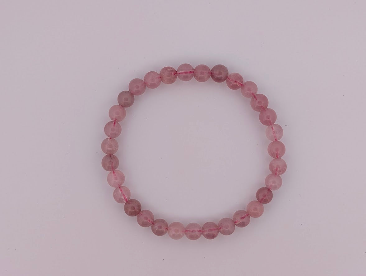 Flatlay of 6mm lavender rose quartz bracelet on neutral background