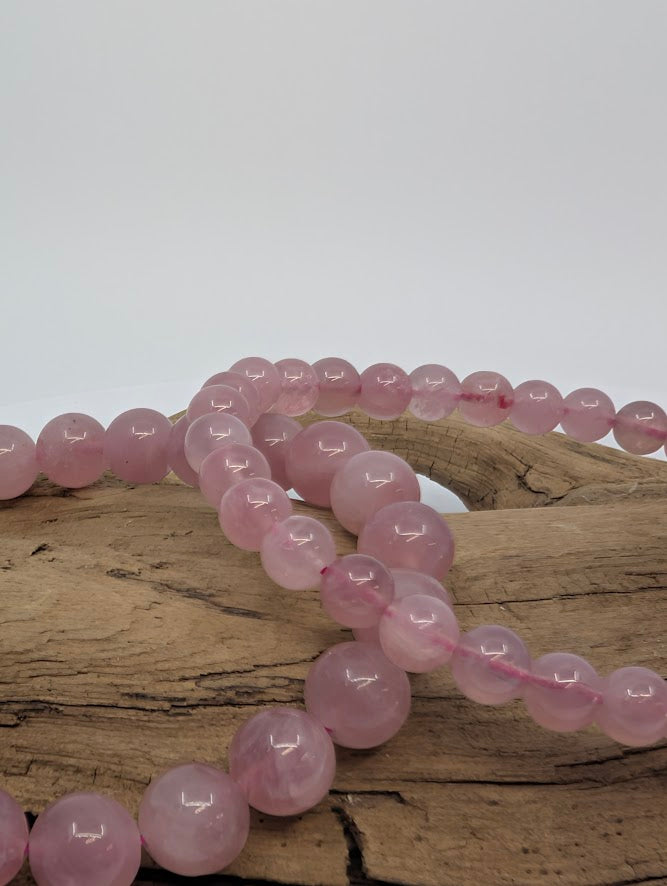 Close-up of 8mm lavender rose quartz beads showing translucent pink-lilac tone