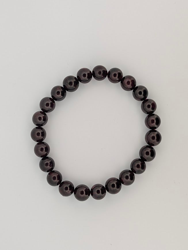 8mm round garnet bracelet flat lay on neutral background