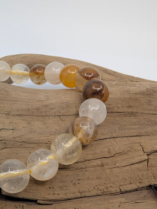 Macro of 8mm Golden Healer Quartz beads showing golden iron-oxide veils
