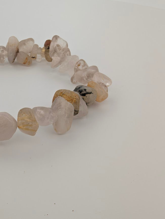 Angled macro of rutilated quartz chips highlighting clarity and inclusions