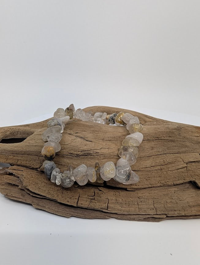 Golden Rutile Quartz chip bracelet on driftwood, showing golden rutile needles in clear quartz
