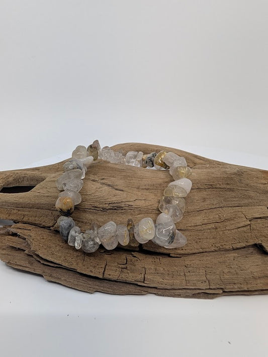 Golden Rutile Quartz chip bracelet on driftwood, showing golden rutile needles in clear quartz