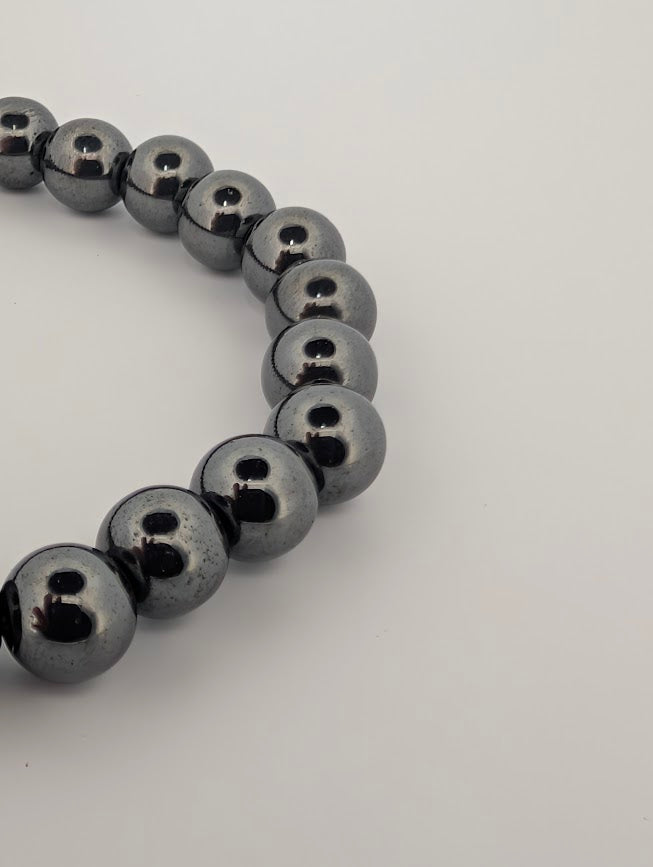 Angled close-up of hematite beads highlighting reflective surface and uniform matching