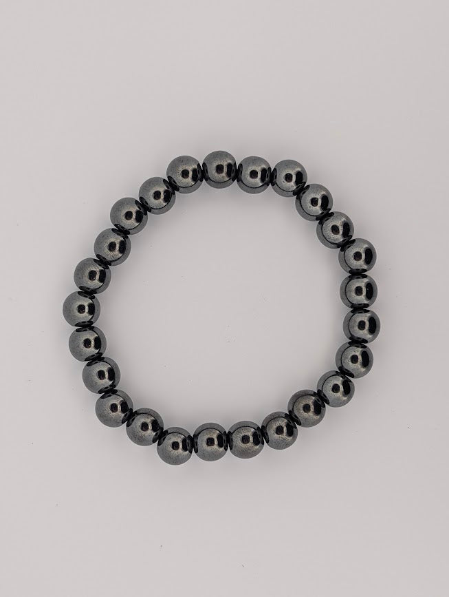 Overhead view of hematite 8mm bracelet on white background