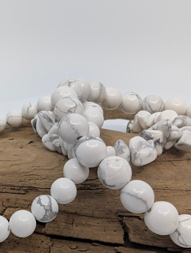 Macro of mixed Howlite bracelets showing undyed white stone and natural grey webbing
