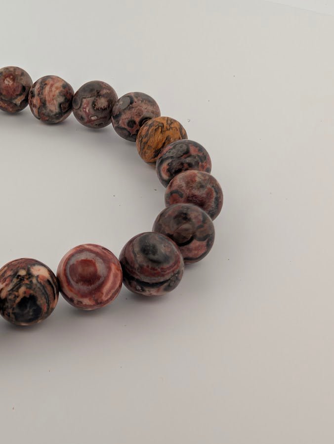 Detail of orbicular jasper patterning with reds, creams, and charcoal