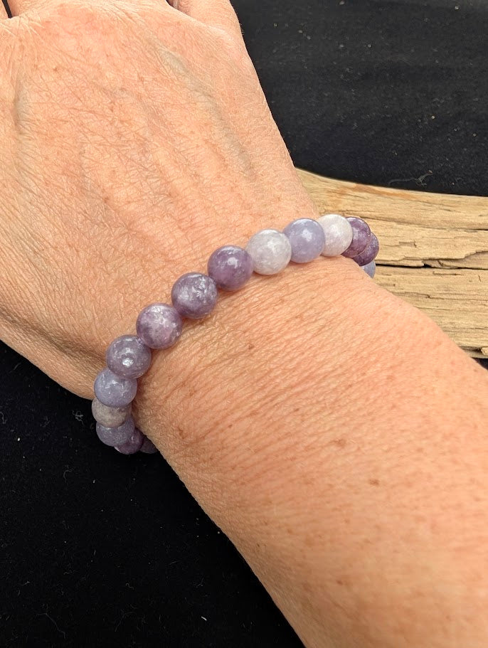 8mm polished Lepidolite beaded stretch bracelet worn on a wrist for size scale.