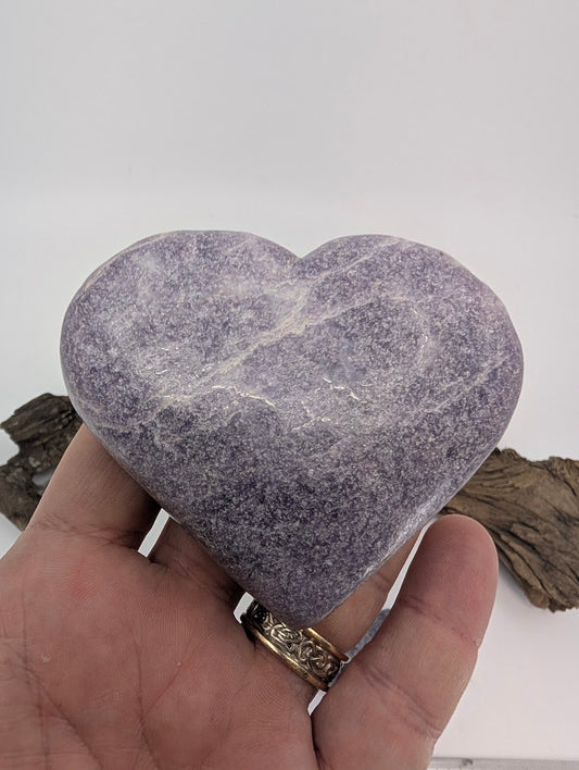 Hand holding a massive 320g Lepidolite heart showing deep violet color.