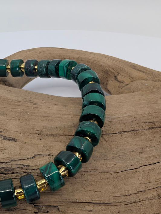 Close-up of natural malachite cube beads with gold spacers and banded patterns