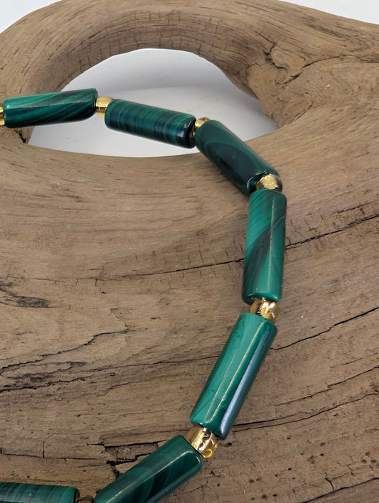 Close-up of 12mm Malachite cylinder beads highlighting the natural copper carbonate bands and high-luster polish.