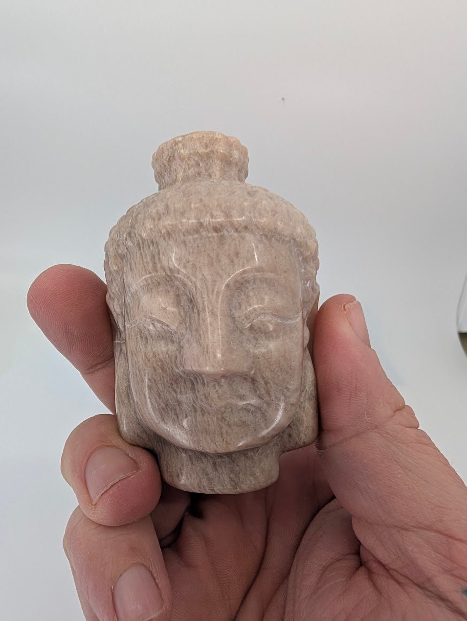 Closeup of Moonstone Buddha head carving showing pearly feldspar sheen