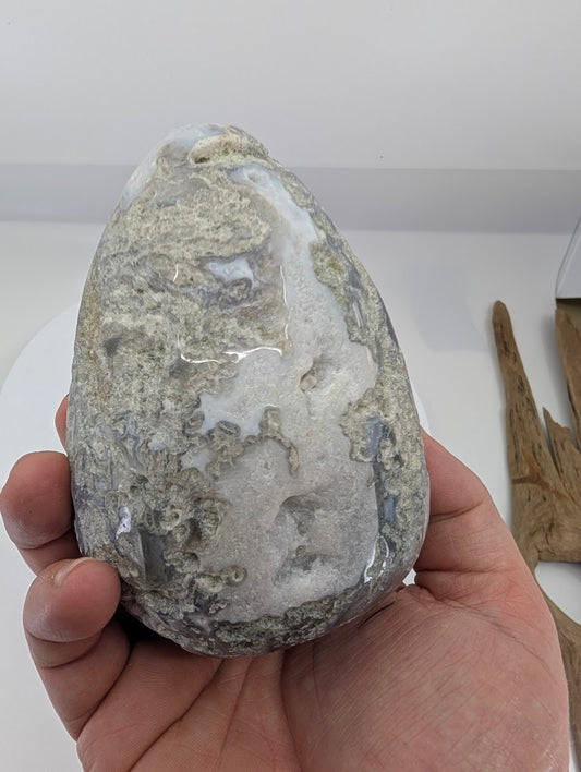 Side view of a large moss agate egg with natural chalcedony zones and organic patterning