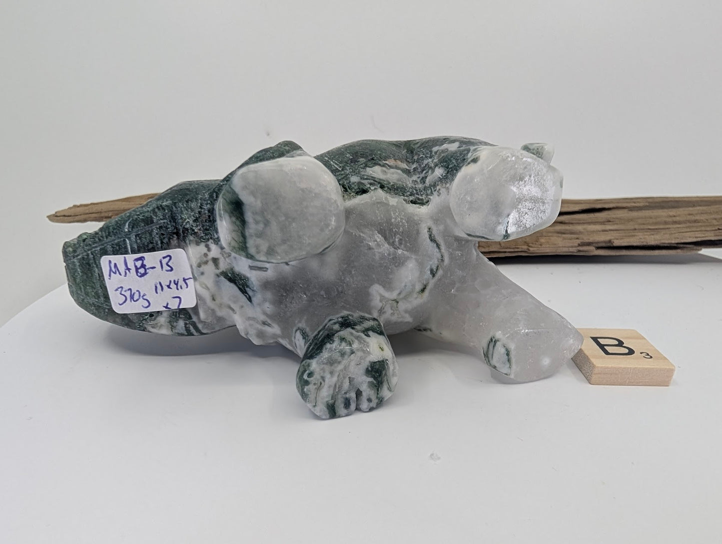 Underside of Moss Agate elephant B with 370g weight label and chalcedony clarity.