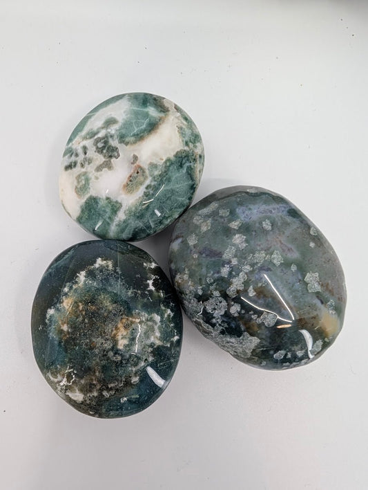Group of Moss Agate palm stones showing natural moss-like inclusions and color variation