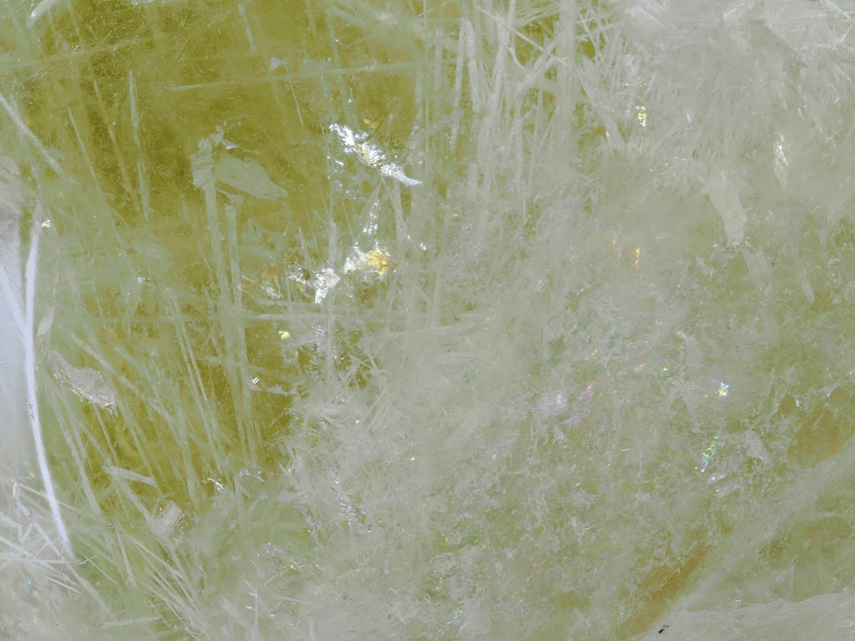 Microscopic detail of silver rutile sprays inside a museum grade citrine sphere.