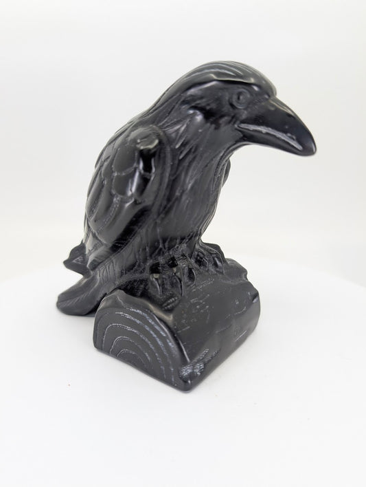 Large polished black obsidian raven carving showing detailed profile