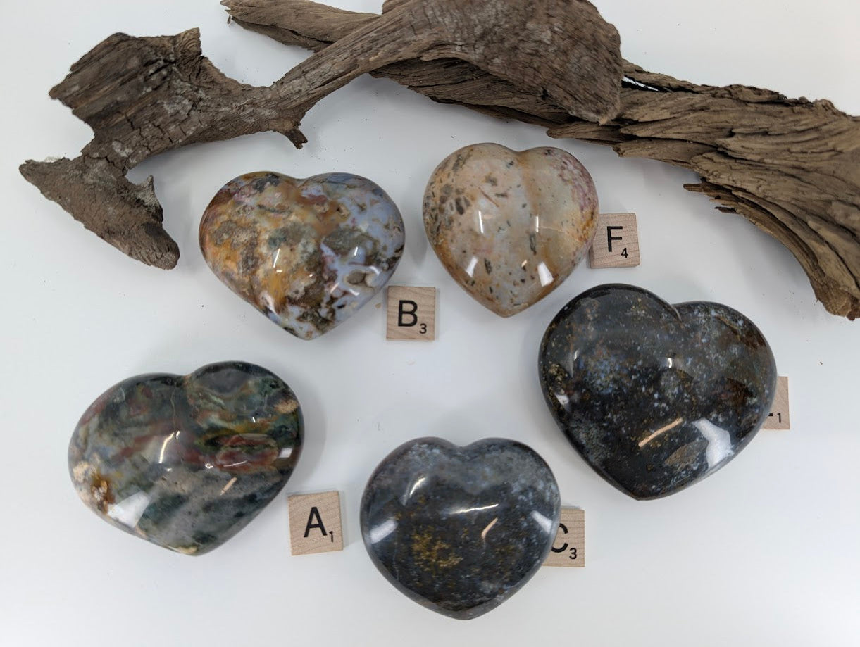 Detail shot of Ocean Jasper hearts showing red, green, and dark galaxy patterns.