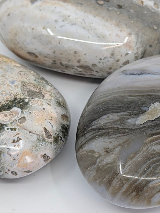 Close-up of Ocean Jasper Palm Stone highlighting natural banding and mossy inclusions