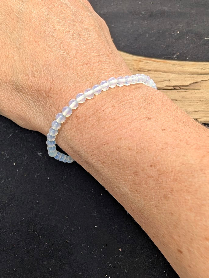 4mm polished Opalite beaded stretch bracelet worn on a wrist for delicate size scale.