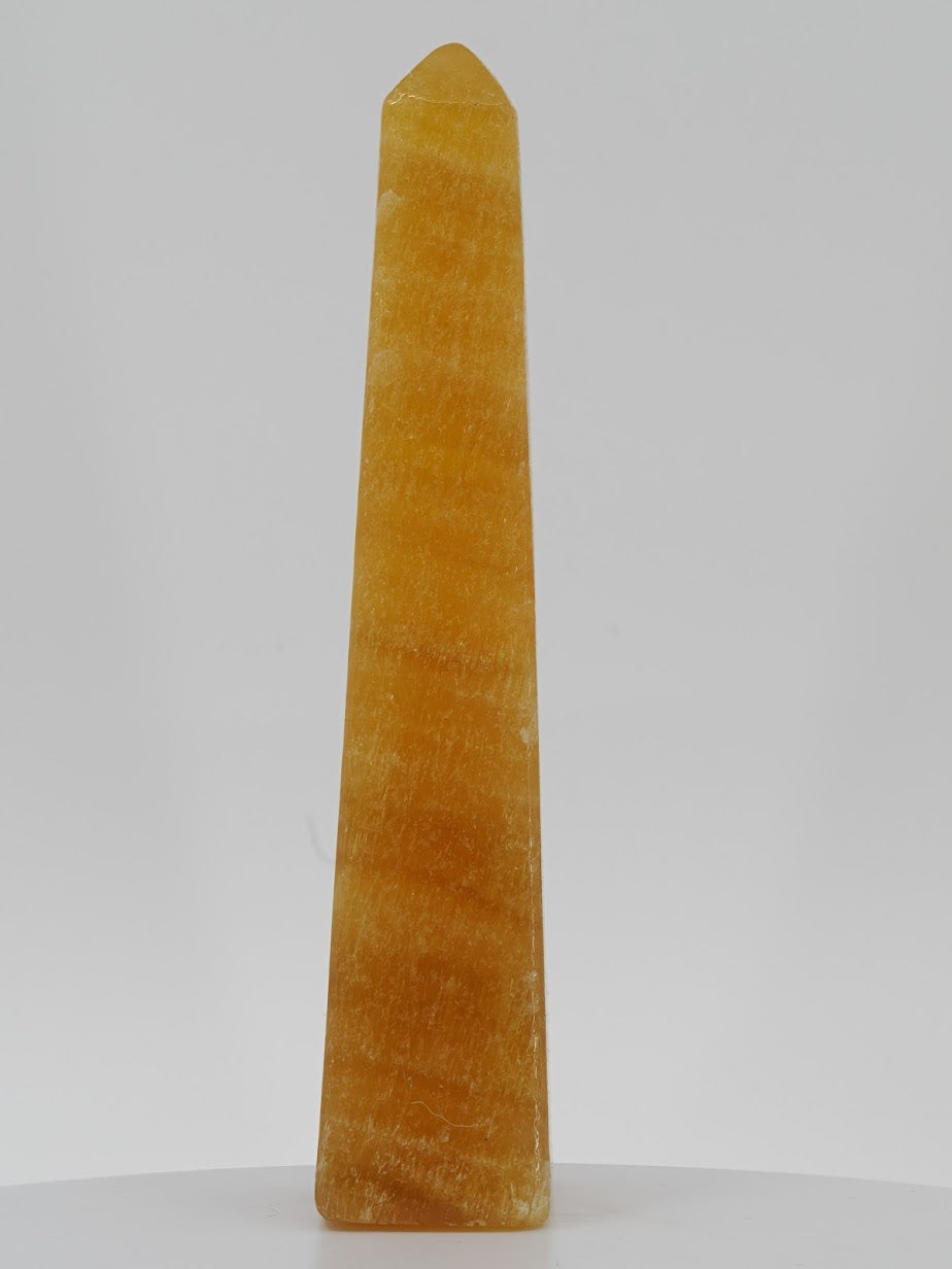 Polished Orange Calcite tower from Pakistan featuring intense marigold orange translucency and natural internal veiling.