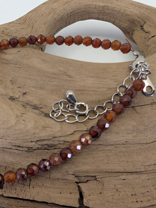 Close-up of 3mm Peach Garnet beads and adjustable silver-toned lobster clasp for a custom fit.