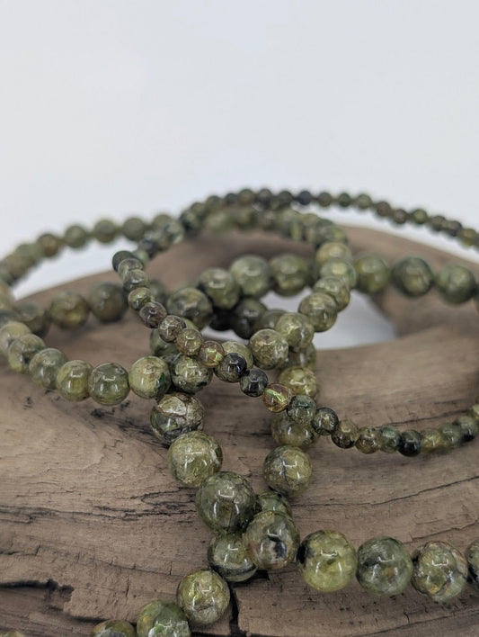 Close-up of multiple peridot bracelets showing natural green and texture