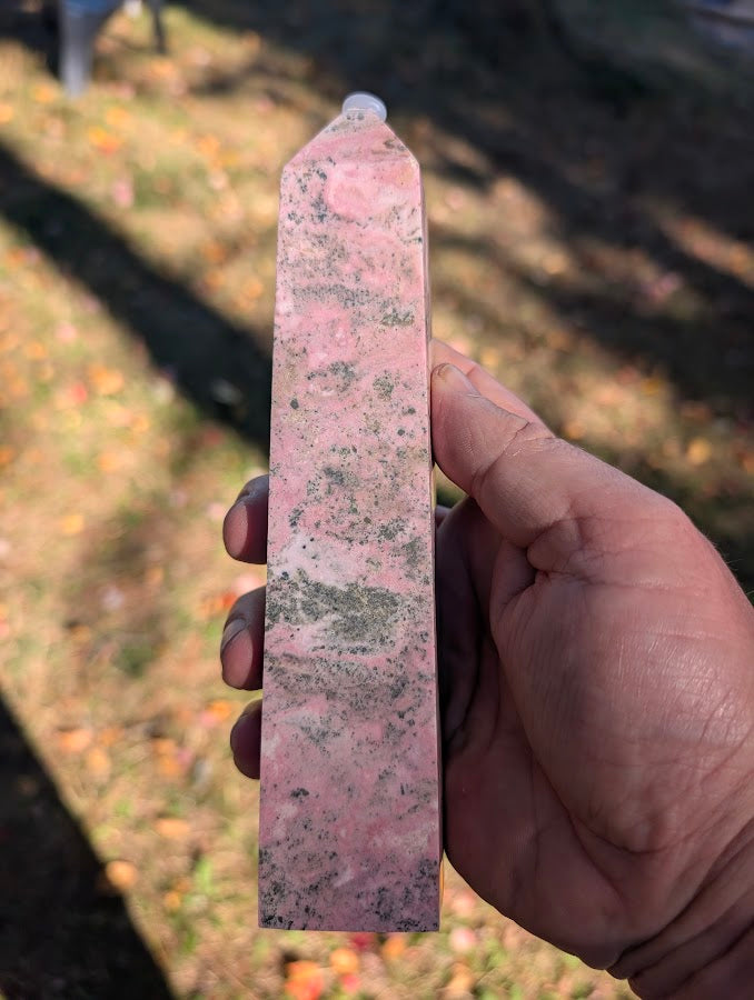 Angled view of rhodonite tower #2 highlighting pink marbling and polished finish