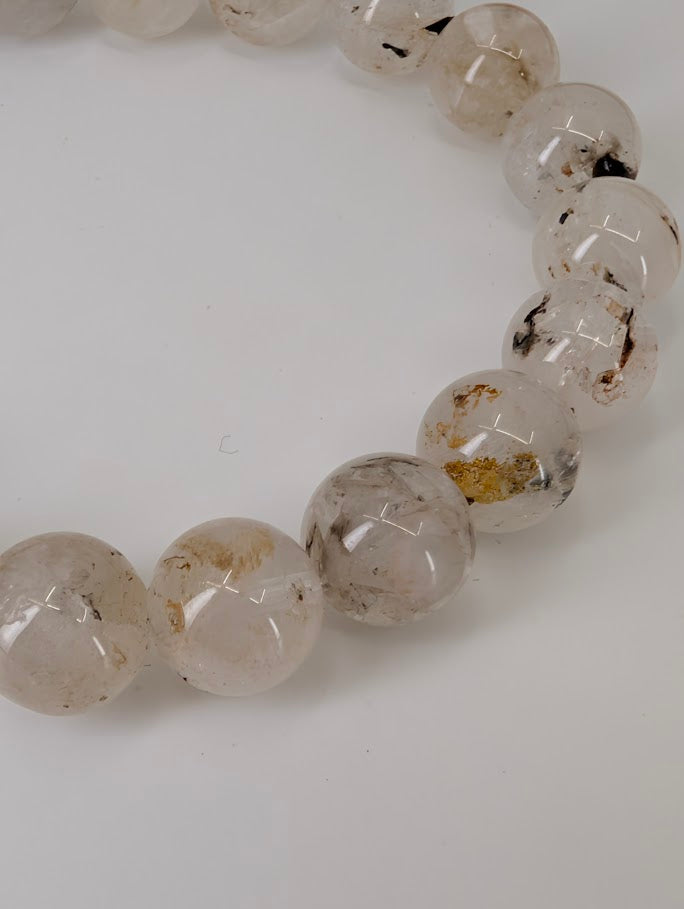 Petroleum Quartz Bracelet detail showing visible oil and carbon inclusions in clear quartz beads