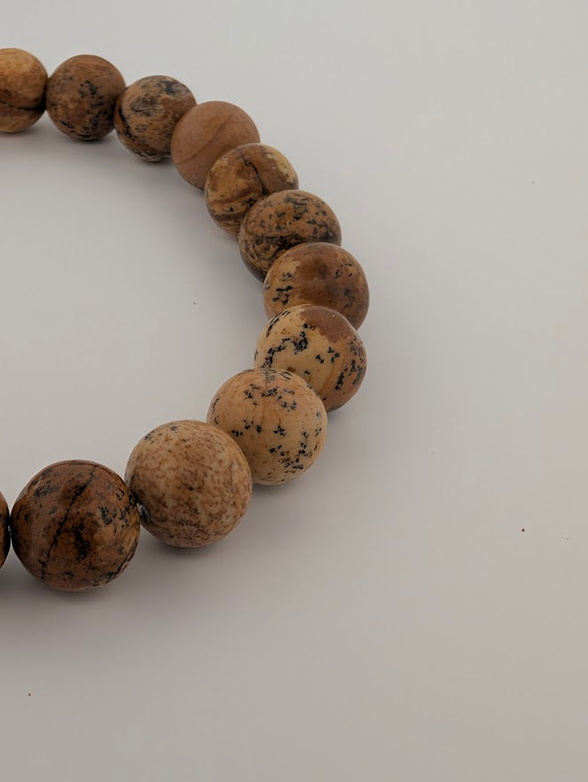 Macro view of curved strand highlighting natural tan and caramel tones of Picture Jasper