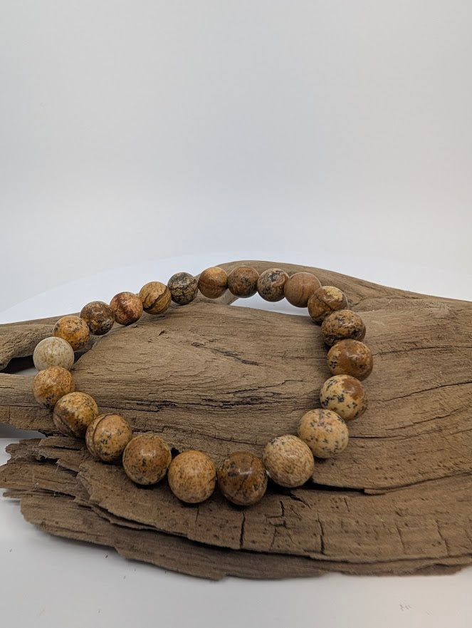 Picture Jasper bracelet with 8mm round beads on driftwood, warm tan and brown landscape patterns